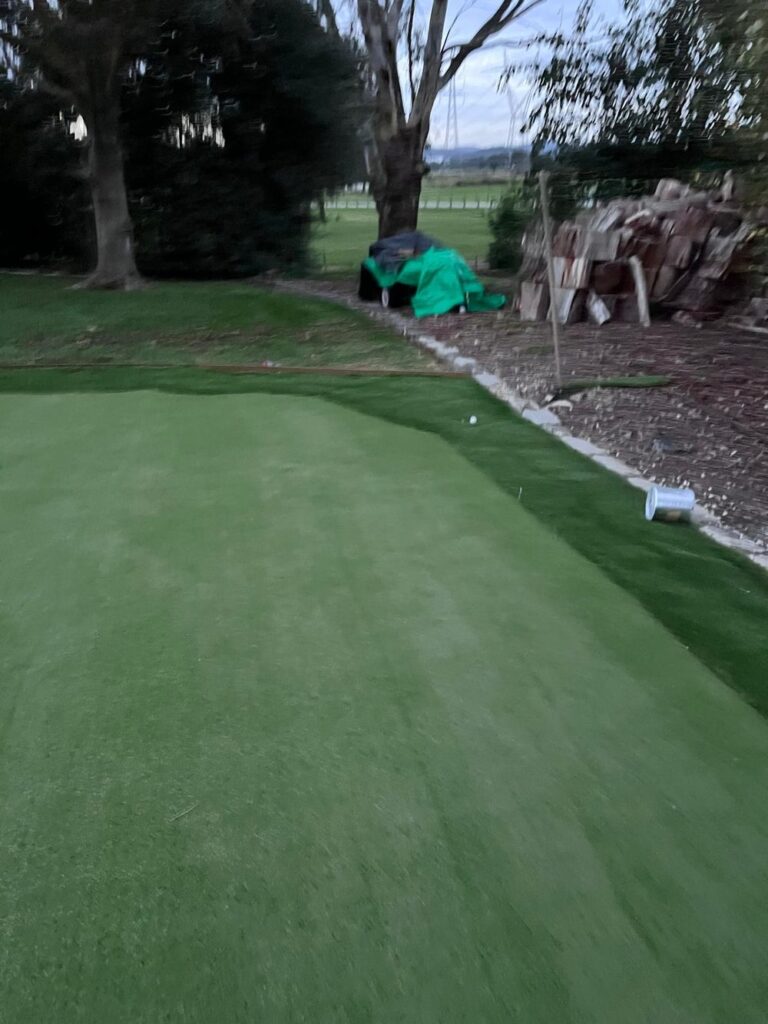 Artificial putting green being power-swept after installation