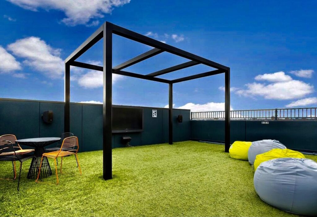 Rooftop artificial turf under a steel pergola